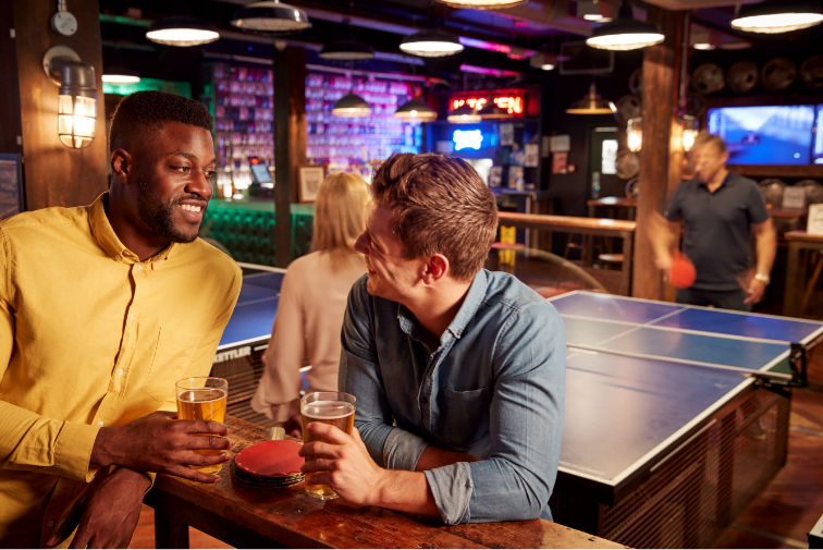 Men Enjoying a drink at a ping pong table
