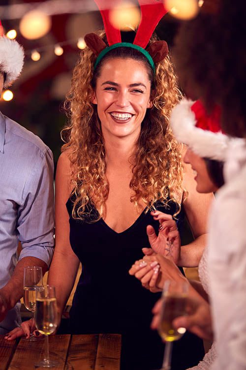 Multi-Cultural Group Of Friends Celebrating Dressing Up For Christmas Party In Bar