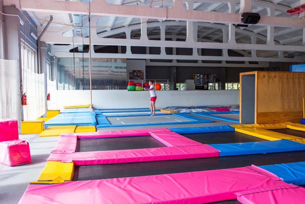 man jumping on a trampoline indoors