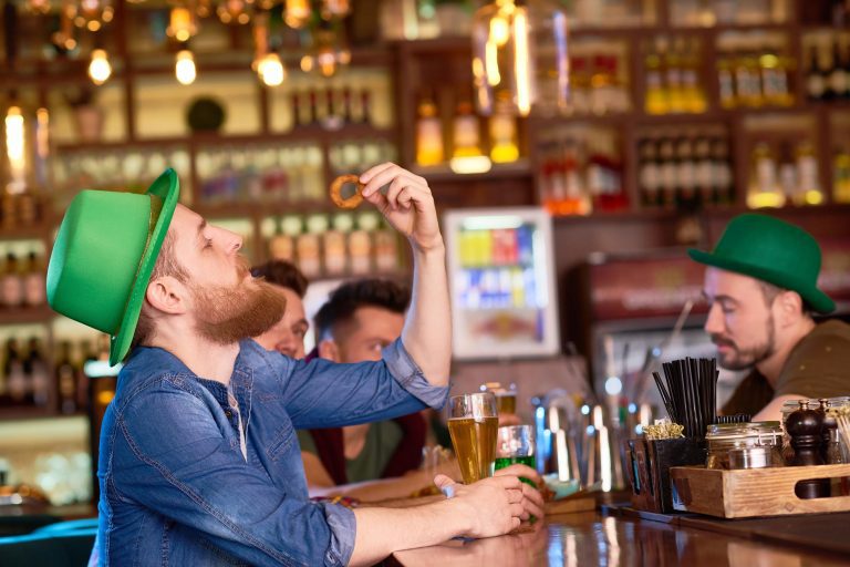 Person drinking and looking at onion ring in a st partricks hat