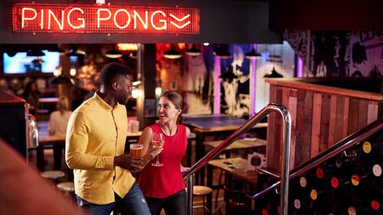 Climbing Stairs with Drinks In Bar