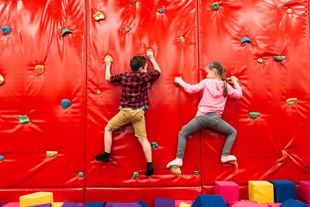 kids climbing on a wall in Entertainment center.