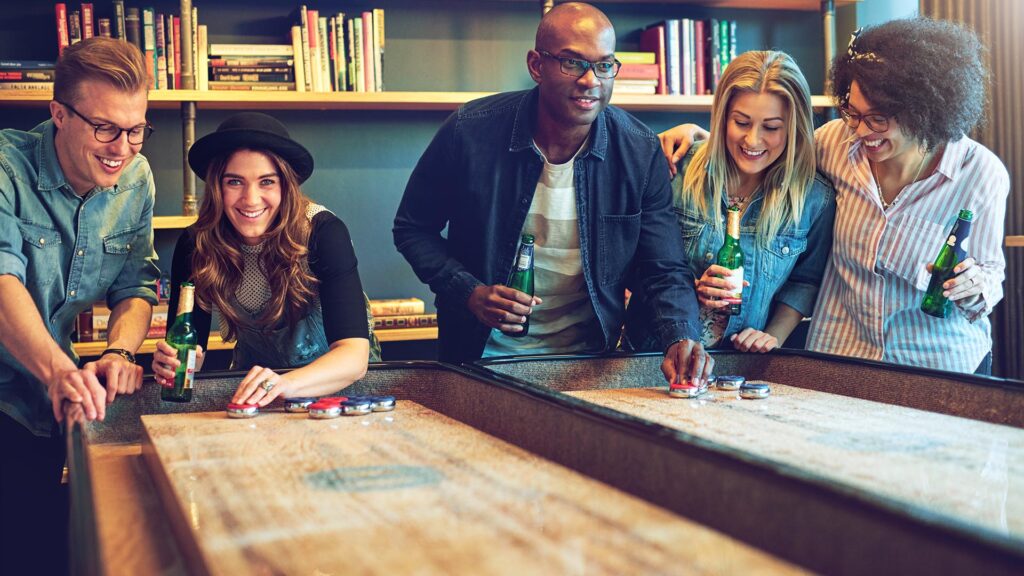 Group of friends having fun playing Shuffleboard