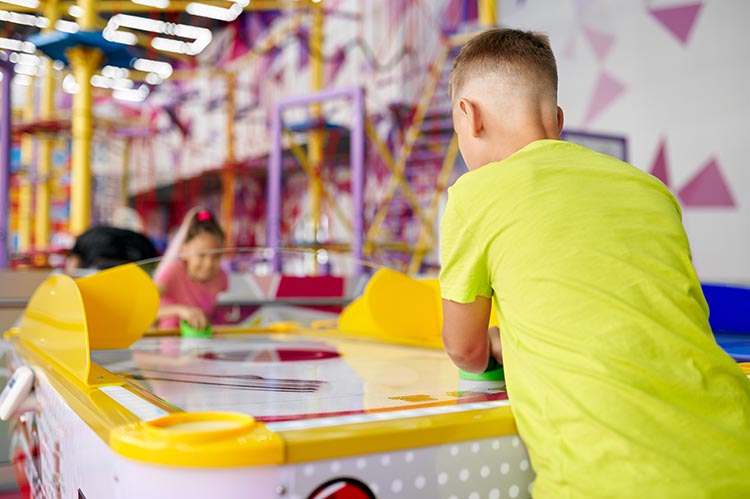 Little boy and girl play Air Hockey