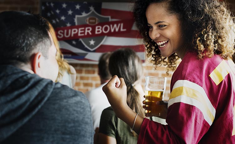 A woman and man cheering for a superbowl play