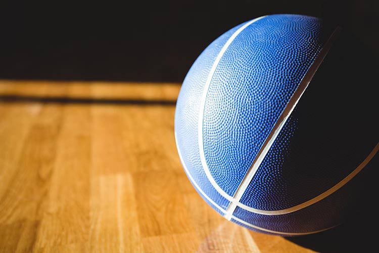 Close up of blue basketball on floor in court