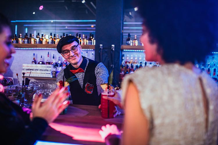 Bartender mixing drinks behind the bar in a nightclub