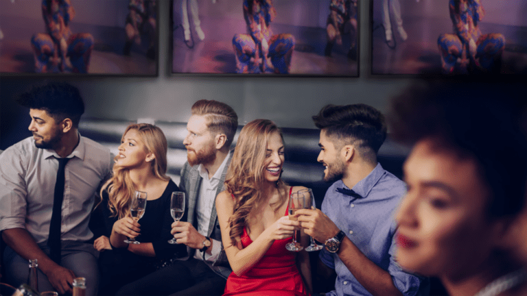 Music video on screen at restaurant with people having a good time