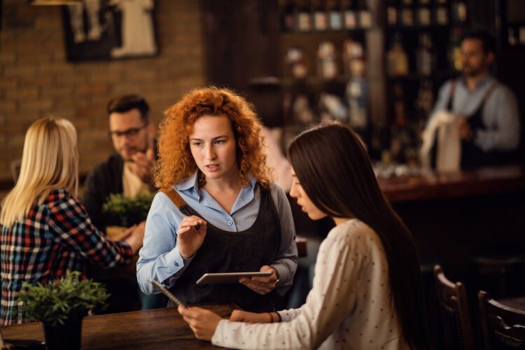 Woman standing with ipad at restaurant