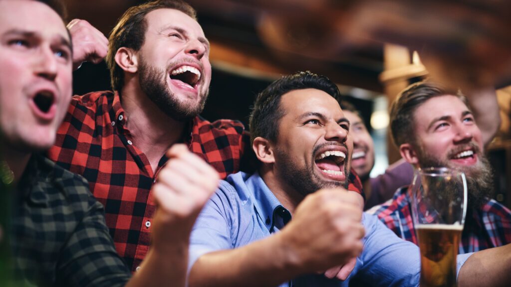Men At a sports bar cheering