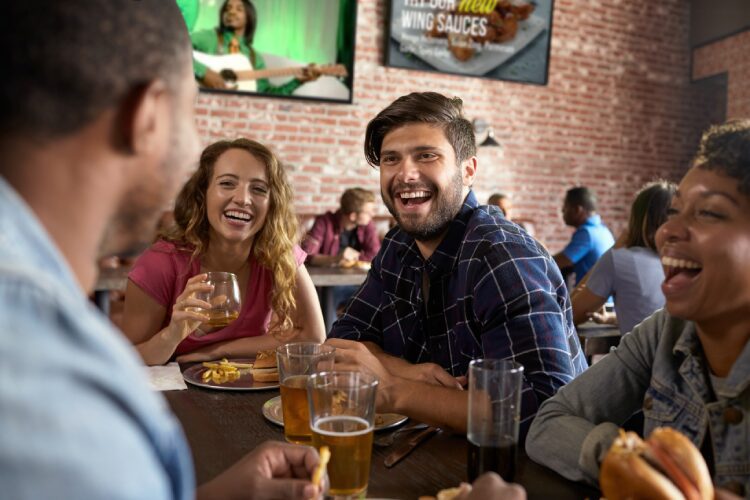 People at the bar drinking and music video on a screen