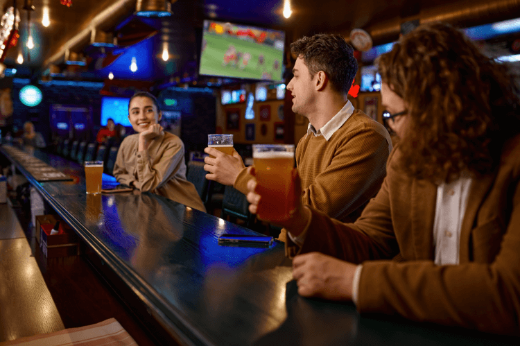 Men at a bar with a woman watching football